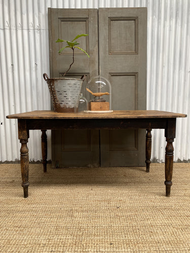 an antique australian pine table with lots of interesting surface texture, evidence of its years of use in the world. a lovely dark aged pine with darker marks and scratches and the odd dash of old whore paint on the surface. 